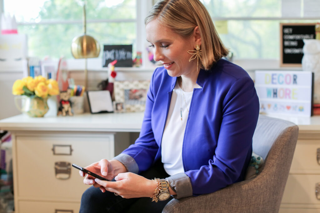 women-in-blue-jacket-using-cell-phone-while-sitting-at-desk